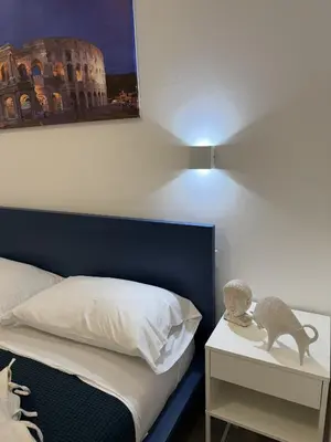 a bedroom with a bed and a lamp on a night stand at Nest Love collazia Roma 1500 mt dal Colosseo in Rome