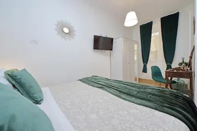 two green ottomans with a cup and a book on top at Domus al Colosseo by Luxury Getaways in Rome