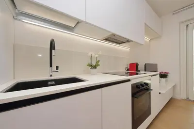 a kitchen with white cabinets and a sink at Contemporary Apartment by Luxury Getaways in Rome