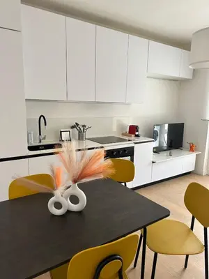a kitchen with a black table with yellow chairs at Contemporary Apartment by Luxury Getaways in Rome