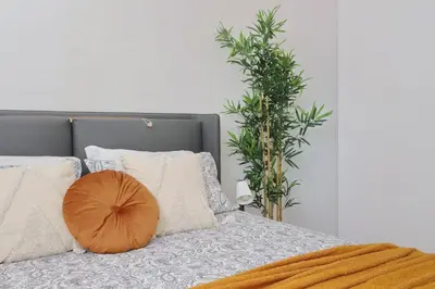 a bed with a pillow on it with two plants at Contemporary Apartment by Luxury Getaways in Rome