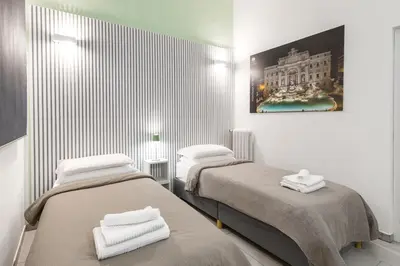 a room with two beds and a painting on the wall at Rome Capital Apartments in Rome