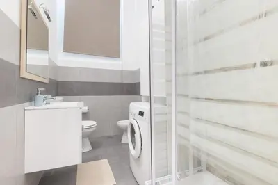 a white bathroom with a toilet and a sink at Rome Capital Apartments in Rome