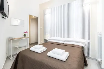 a bedroom with a large bed with two towels on it at Rome Capital Apartments in Rome