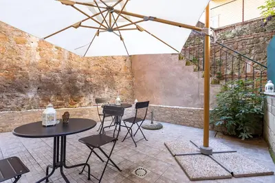 a patio with two tables and chairs and an umbrella at Rome Capital Apartments in Rome