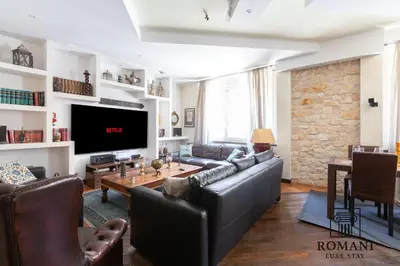 a living room with a leather couch and a tv at Luxury Vatican Suite with Sauna in Rome