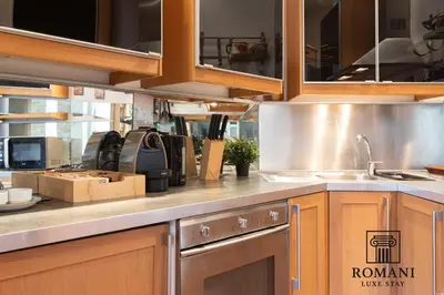 a kitchen with wooden cabinets and a stainless steel sink at Luxury Vatican Suite with Sauna in Rome