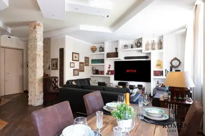 a living room with a table and a tv at Luxury Vatican Suite with Sauna in Rome