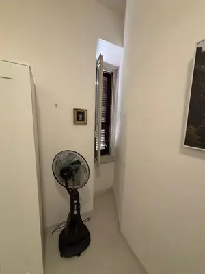 a black fan in a room with a window at Testaccio Immobiliare in Rome