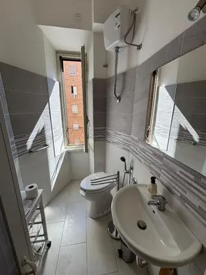 a bathroom with a sink and a toilet and a window at Testaccio Immobiliare in Rome