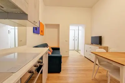 a kitchen and living room with a couch and a table at Poliziano Boutique Apartment in Rome