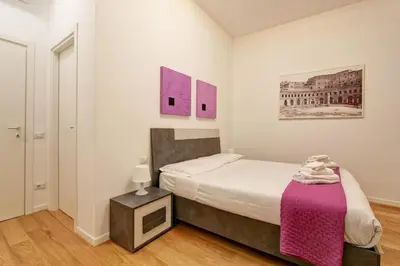 a bedroom with a bed with a pink blanket at Poliziano Boutique Apartment in Rome