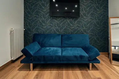 a blue couch in a living room with a wall at Casa Mia San Pietro in Rome
