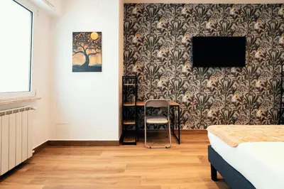 a bedroom with a table and a tv on a wall at Casa Mia San Pietro in Rome