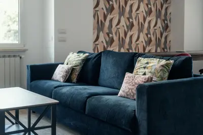 a blue couch in a living room with a table at Casa Mia San Pietro in Rome