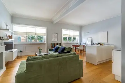 a living room with a green couch and a kitchen at iFlat Charming Hideaway Apt by the Vatican in Rome