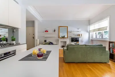 a kitchen and living room with a green couch at iFlat Charming Hideaway Apt by the Vatican in Rome