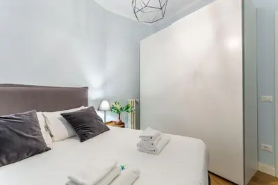 a bedroom with a white bed with towels on it at iFlat Charming Hideaway Apt by the Vatican in Rome