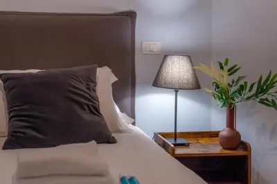 a bedroom with a bed with a lamp and a plant at iFlat Charming Hideaway Apt by the Vatican in Rome