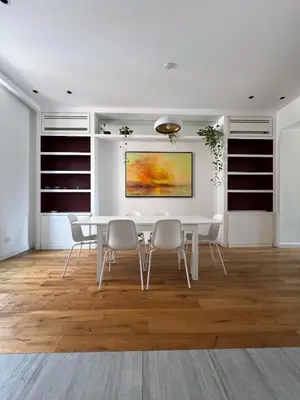 a white dining room with a white table and chairs at Zaffiro FIUME charming apartment in Rome
