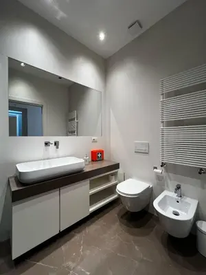 a bathroom with a sink and a toilet and a mirror at Zaffiro FIUME charming apartment in Rome