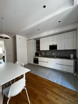 a kitchen with white cabinets and a table and chairs at Zaffiro FIUME charming apartment in Rome