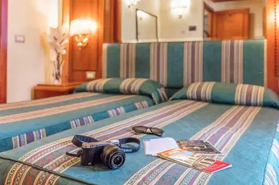a camera on a bed in a hotel room at Raeli Hotel Lazio in Rome