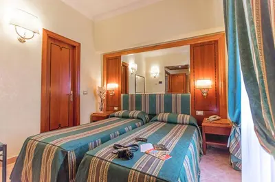 a hotel room with a bed and a mirror at Raeli Hotel Lazio in Rome