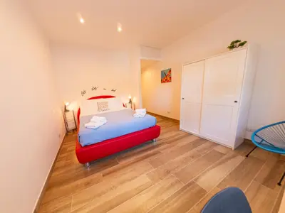 a bedroom with a red bed and a closet at New Cozy APT, close to Downtown in Rome