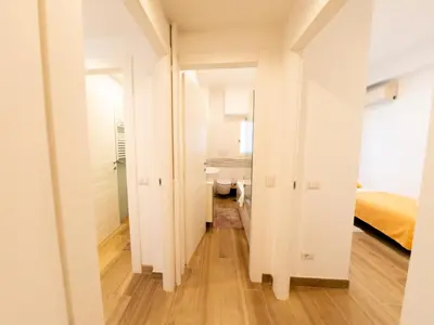 a corridor of a room with a bedroom and a bed at New Cozy APT, close to Downtown in Rome