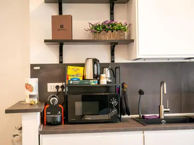 a kitchen with a counter with a microwave and a sink at New Cozy APT, close to Downtown in Rome