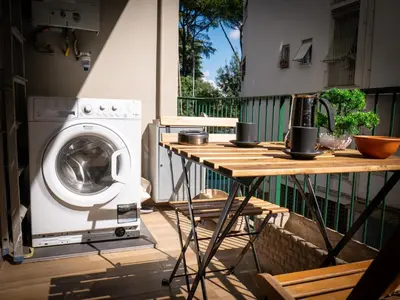 a washing machine sitting next to a table on a balcony at New Cozy APT, close to Downtown in Rome