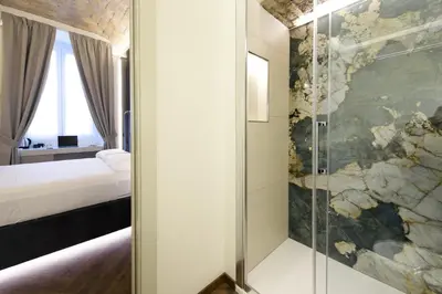 a bedroom with a shower with a glass door at Antinous Suites in Rome