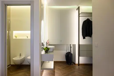a white bathroom with a toilet and a sink at Antinous Suites in Rome