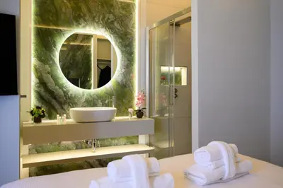 a bathroom with a sink and a mirror and towels at Antinous Suites in Rome