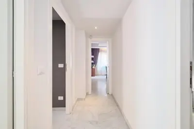 a hallway with white walls and white floors at Vatican Apartment 4 Bedrooms AC in Rome