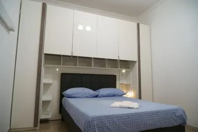 a bedroom with a bed with blue pillows and white cabinets at Apartment16 in Rome