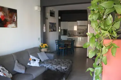 a living room with a gray couch and a kitchen at Casa Fradella in Rome