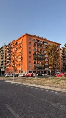 an orange building with cars parked in a parking lot at Casa Fradella in Rome