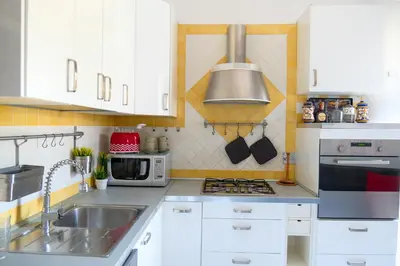 a kitchen with white cabinets and a sink and a microwave at Wanderlust RHome - Scopri Roma e sogna il mondo! in Rome