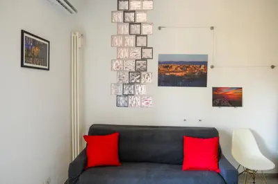 a living room with a blue couch with red pillows at Wanderlust RHome - Scopri Roma e sogna il mondo! in Rome