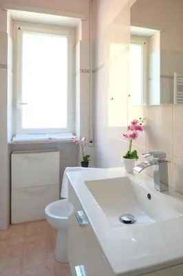 a bathroom with a sink and a toilet and a window at Wanderlust RHome - Scopri Roma e sogna il mondo! in Rome