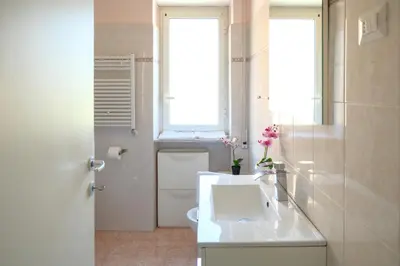 a white bathroom with a sink and a window at Wanderlust RHome - Scopri Roma e sogna il mondo! in Rome