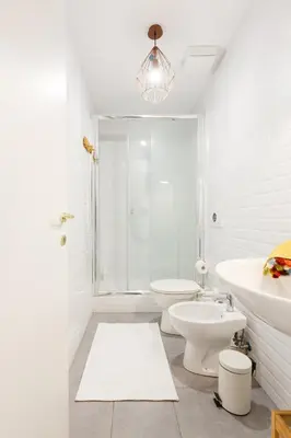 a white bathroom with a toilet and a sink at Lovely apt in Rome! in Rome