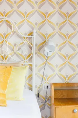 a bedroom with a gold and white patterned wall at Lovely apt in Rome! in Rome
