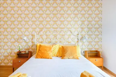 a bedroom with a bed with orange pillows and a wall at Lovely apt in Rome! in Rome