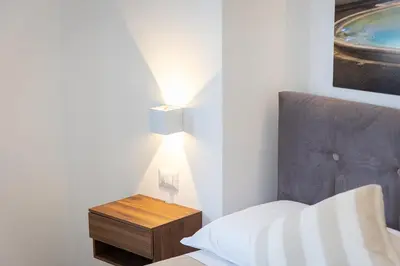 a bedroom with a bed and a nightstand with a lamp at Luxury Rooms near St Peter in Rome