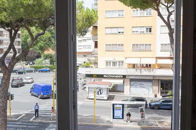 a window with a view of a city street with cars at Luxury Rooms near St Peter in Rome