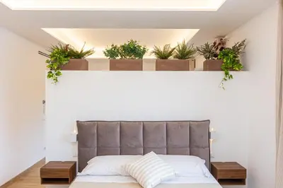 a bed in a room with potted plants on a wall at Luxury Rooms near St Peter in Rome