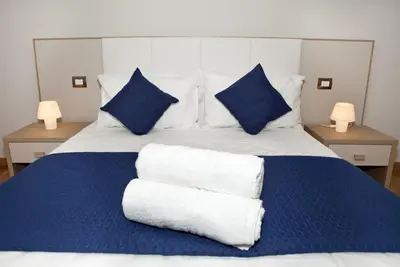 a blue and white bed with blue pillows on it at Spanish Steps House Vittoria in Rome